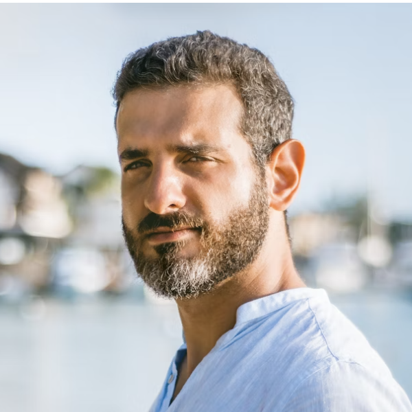 Man with beard in white shirt outdoors